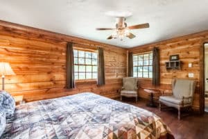 King bed, chairs and windows in the bedroom of the Garnet cabin at Mountain Sky Guest Ranch