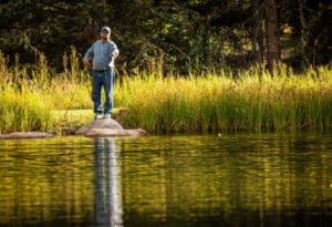Man getting ready to cast line into river near Mountain Sky Guest Ranch's property