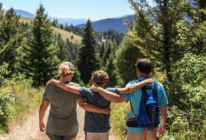Family of hikers walking down trail near Mountain Sky Guest Ranch