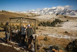 Group shooting at Mountain Sky's clay shooting range with snowy mountains in background