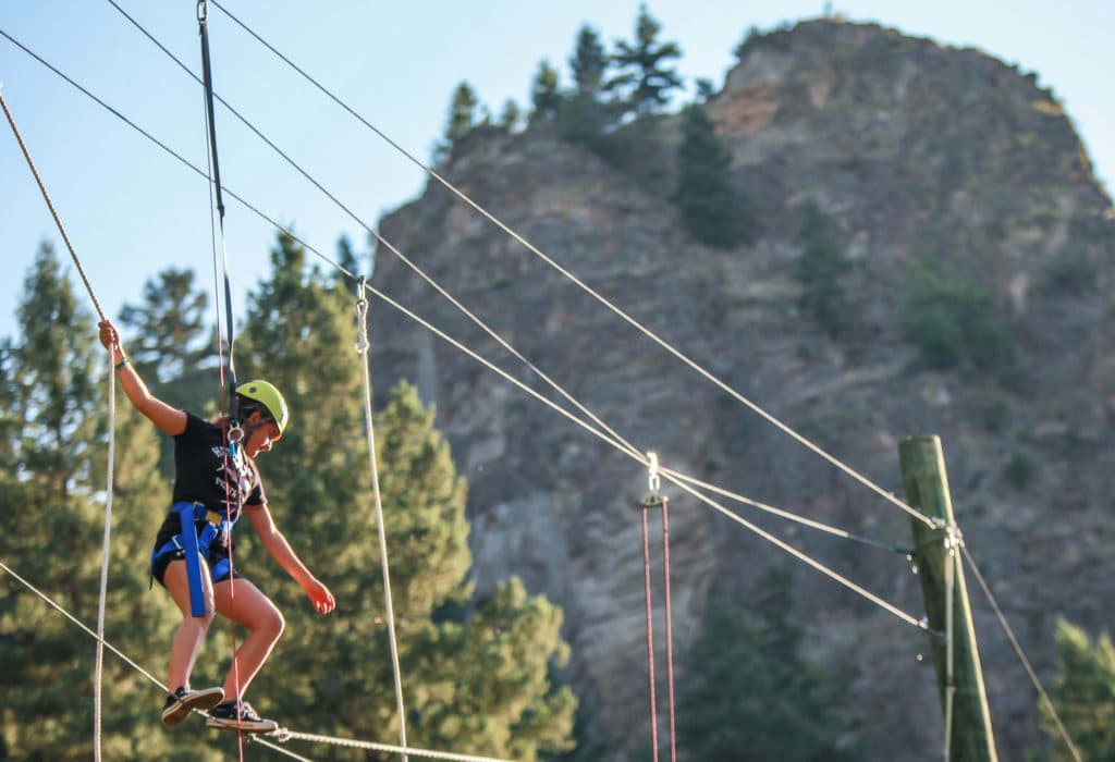 Woman traversing ropes course at Mountain Sky Guest Ranch challenge course
