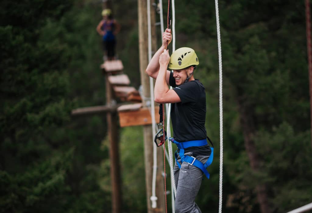 Man climbing across ropes course at Mountain Sky Guest Ranch