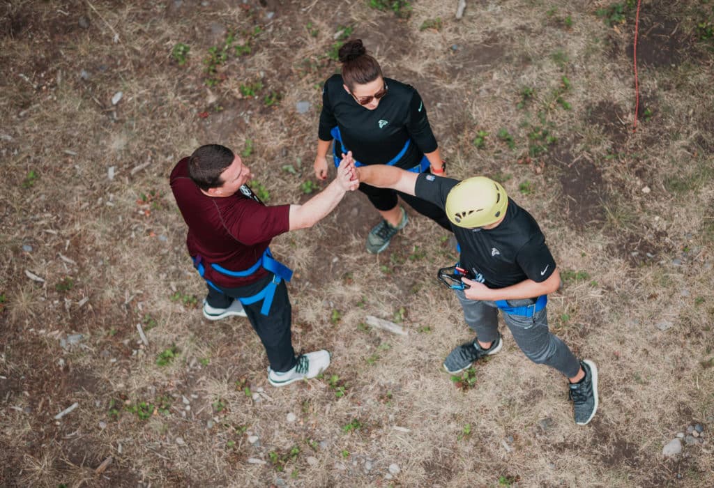 Team high-fiving after completing challenge course at Mountain Sky Guest Ranch