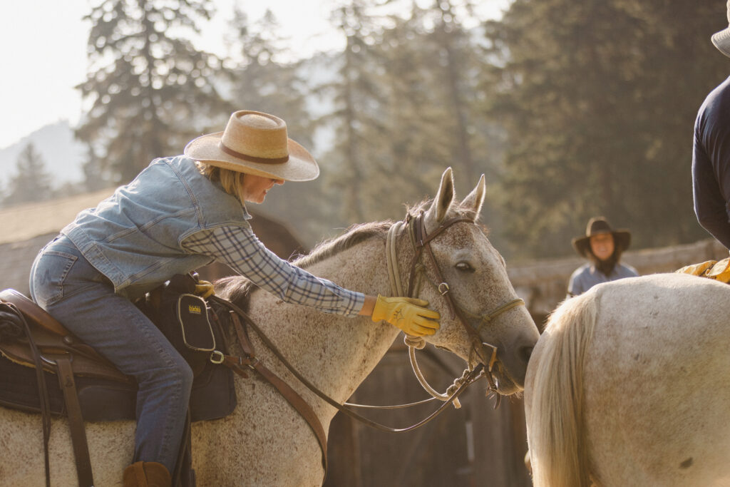 A guest pets a horse at Mountain Sky Guest Ranch in Montana.